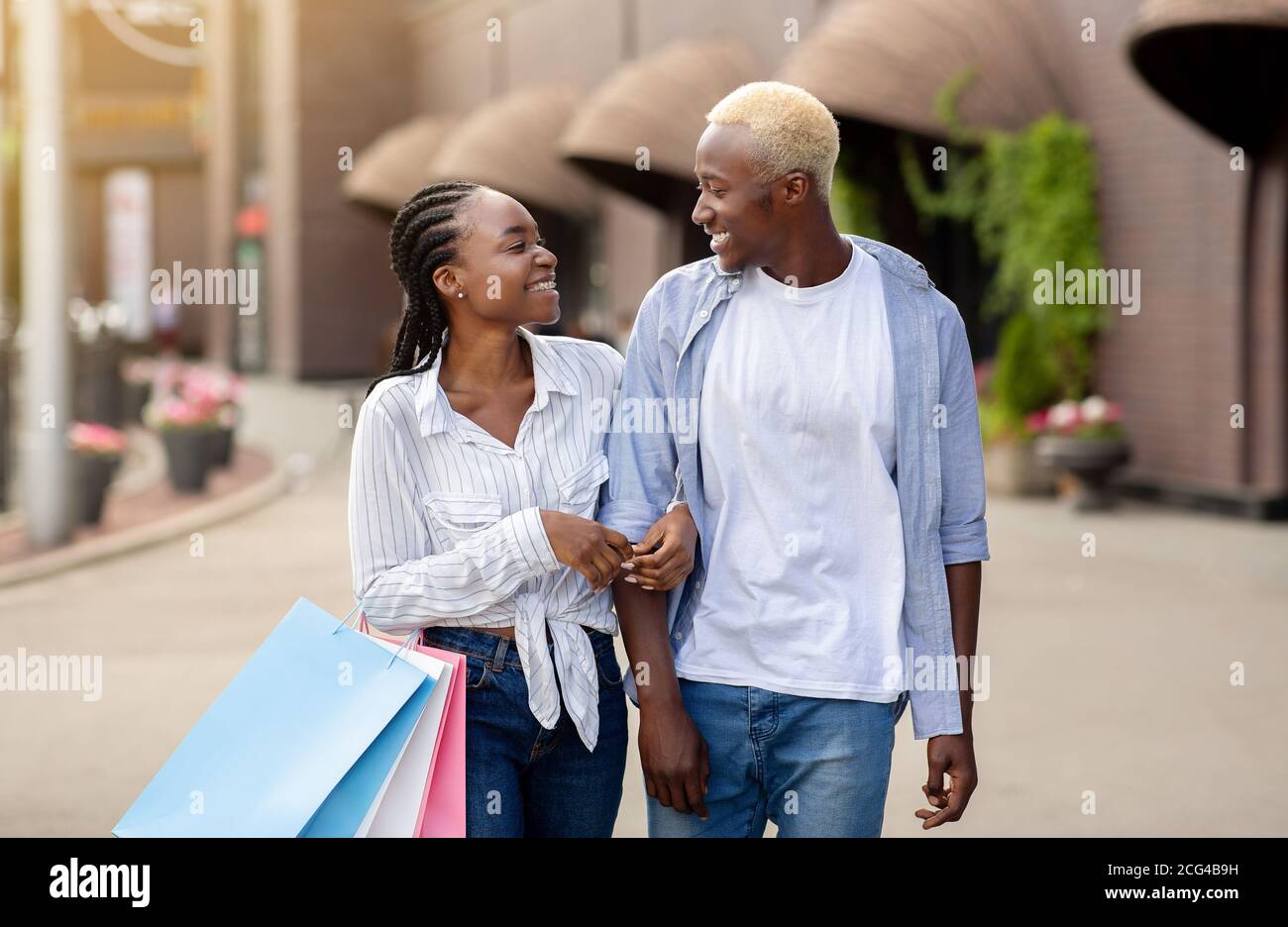 In edizione limitata e mega sconti. Allegra coppia afroamericana con borse per la spesa Foto Stock