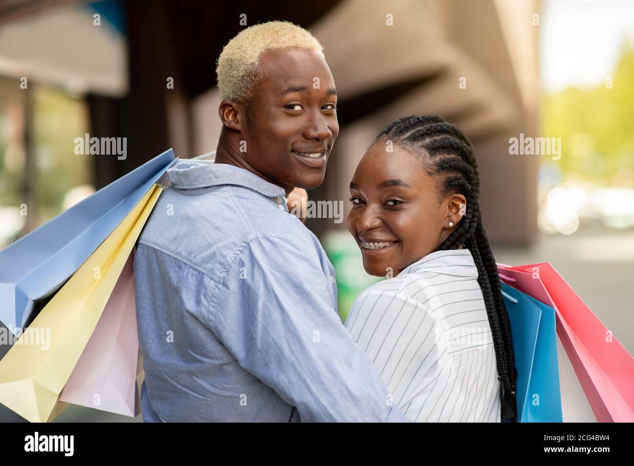 Shopping, moda e divertimento. Ritratto di una bella coppia afro-americana che tiene borse colorate Foto Stock