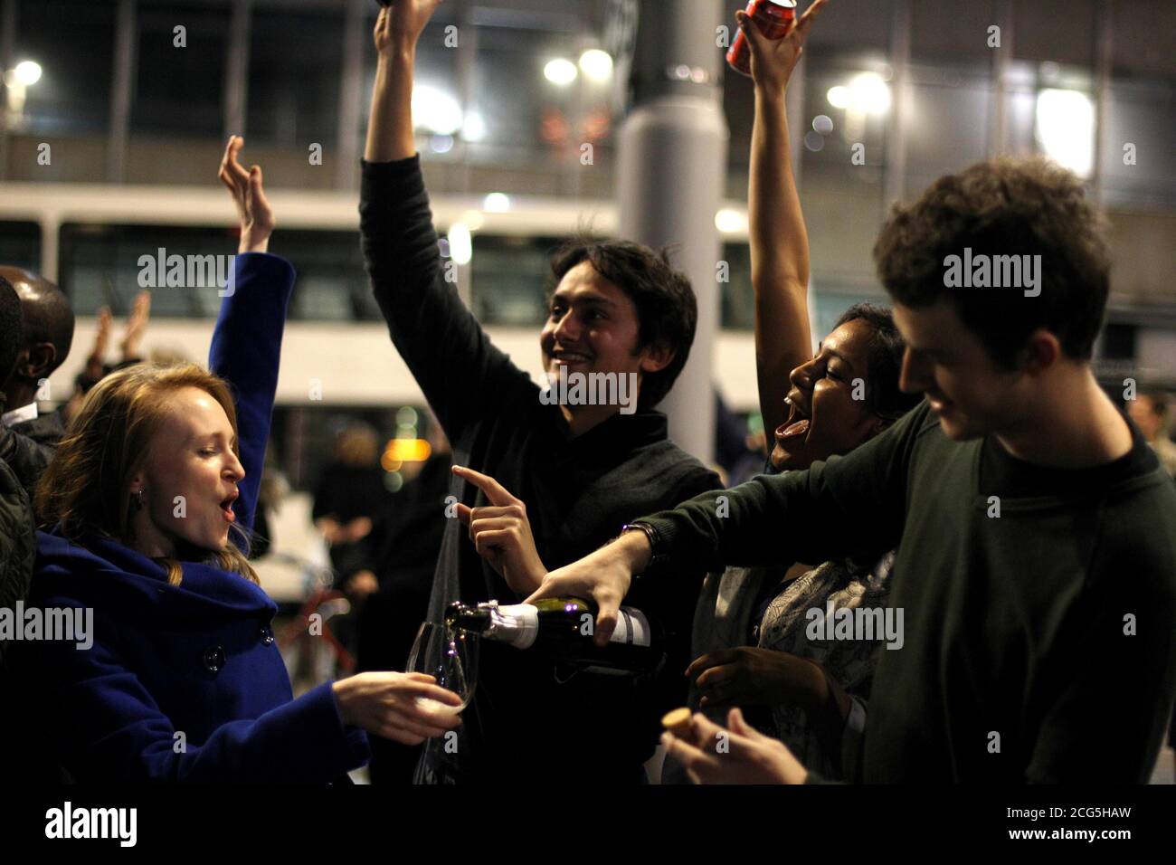 (Da sinistra) Natasha Ambigaibalan, Chris Loveridge, Koshang Desai e Kam Ansari aprono una bottiglia di champagne nella Piazza del mercato Vecchio, Nottingham, mentre celebrano l'inizio del nuovo anno. Foto Stock