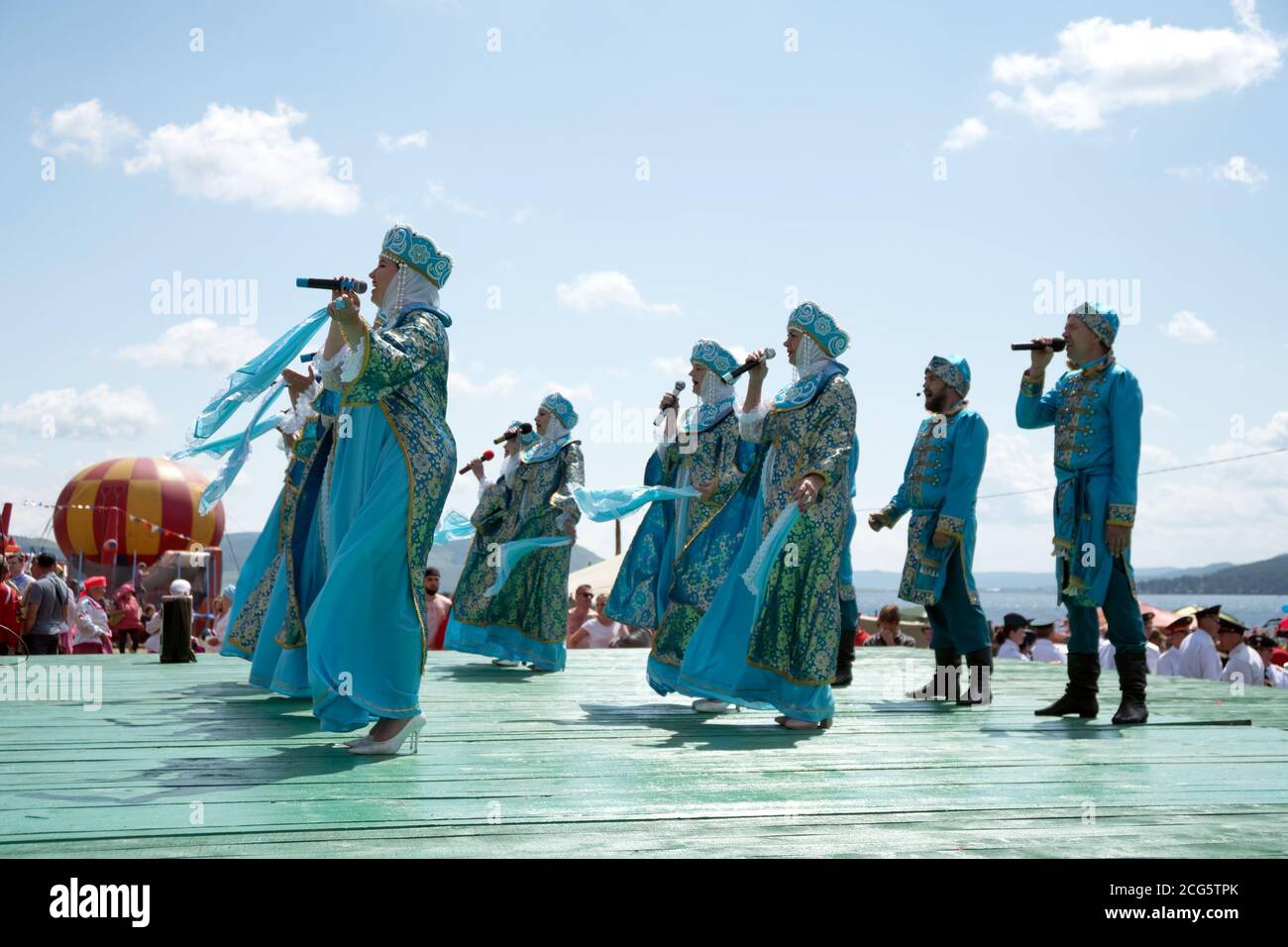 L'ensemble in costumi popolari russi canta su un palco del lungomare, sulle rive del Big Lake, al festival musicale di Caratag. Regione di Krasnoyarsk. RUS Foto Stock