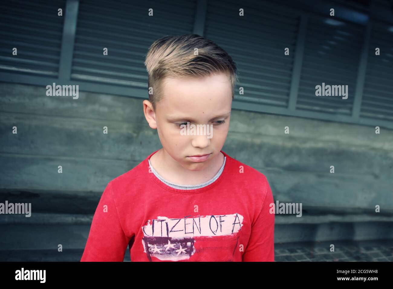 Carino piccolo blu occhi caucasico biondo ragazzo sembra triste e. Frustrato.He sta osservando con espressione pensiva di dolore nel suo face.emotive faccia di espressione Foto Stock