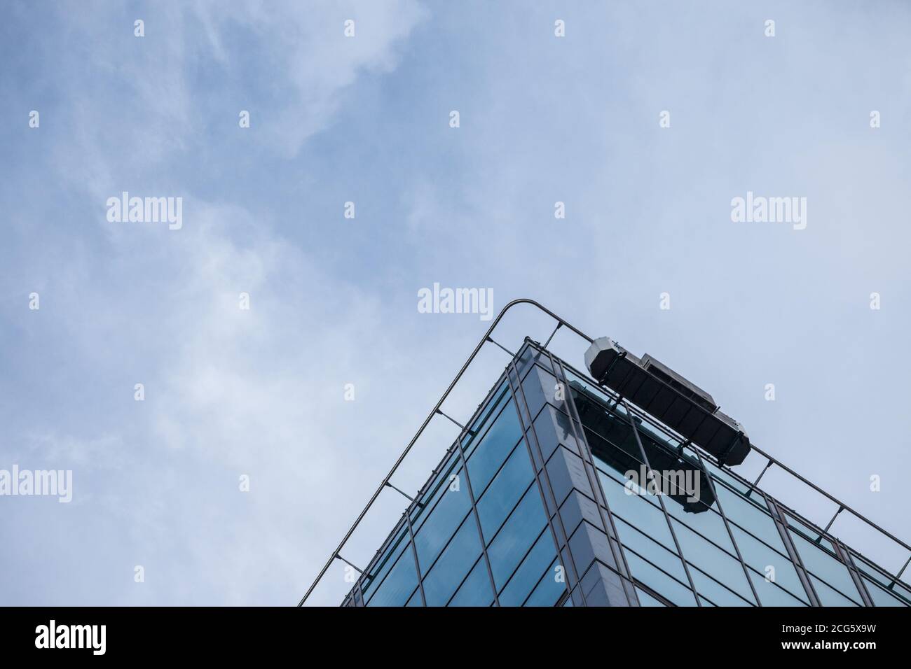 Piattaforma di pulizia delle finestre in cima a un alto edificio di uffici grattacieli utilizzati dai lavoratori per mantenere i vetri esterni della torre. Immagine Foto Stock
