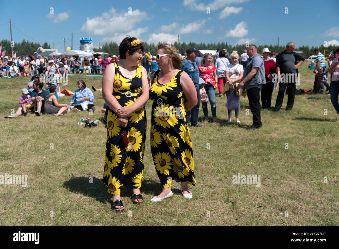 Due donne nella stessa estate si levano in piedi in una radura fra il pubblico al festival di musica di Karatag. Regione di Krasnoyarsk. Russia. Foto Stock