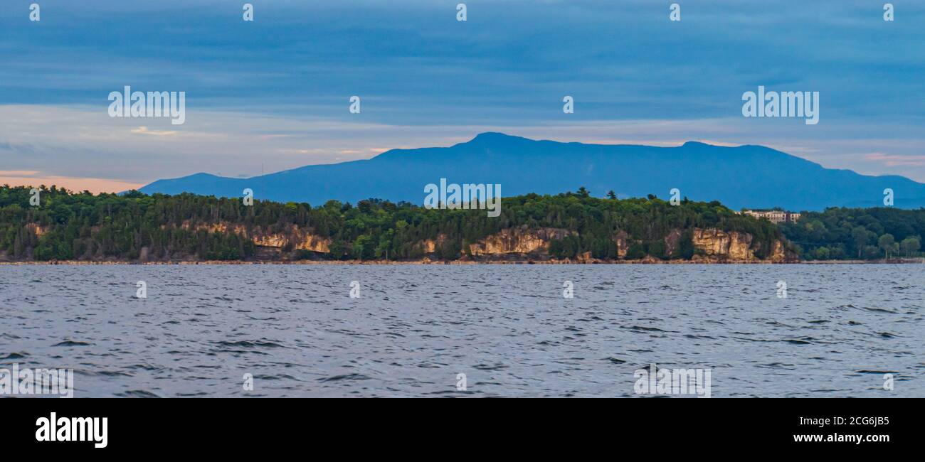 Scogliere rocciose lungo il Lago Champlain con il Monte Mansfield nel sfondo Foto Stock