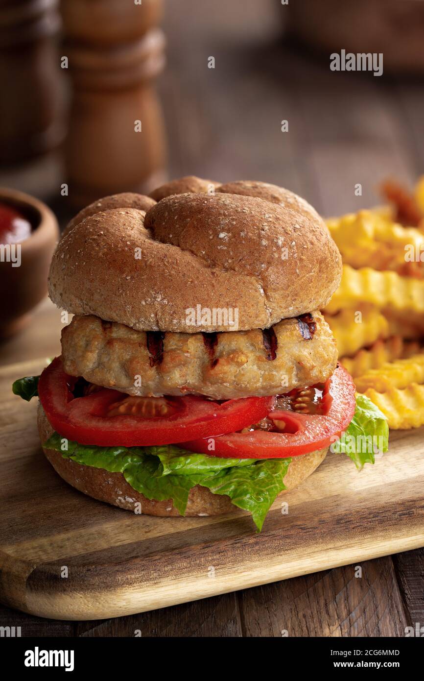Hamburger di tacchino alla griglia con pomodoro e lattuga sul grano intero bun Foto Stock