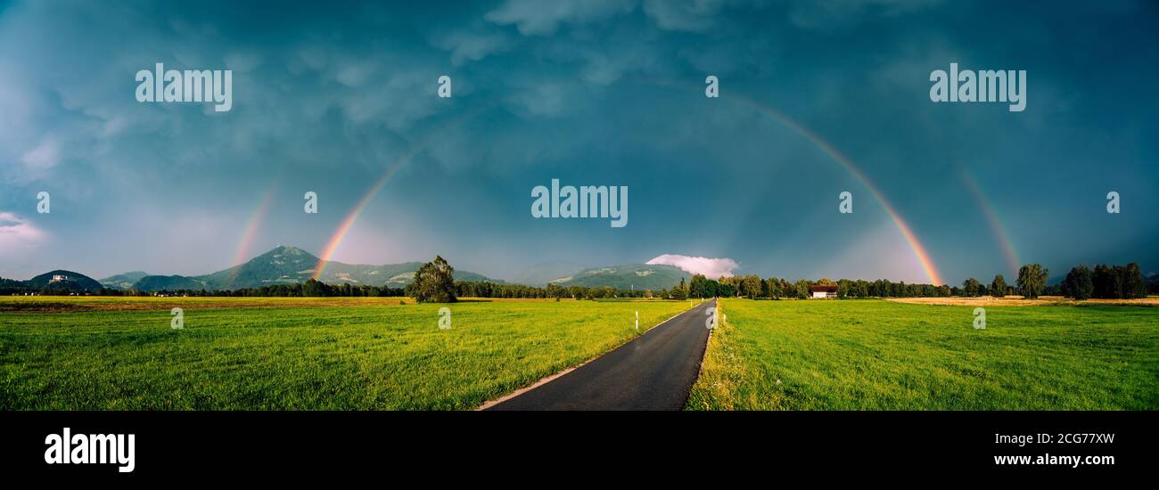 Doppio arcobaleno su una strada attraverso il paesaggio rurale, Salisburgo, Austria Foto Stock