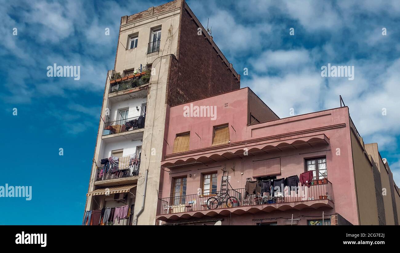 Via della città con casa colorata di architettura unica, vari balconi pieni di roba e lavanderia appeso. Barcellona, Spagna. Foto Stock