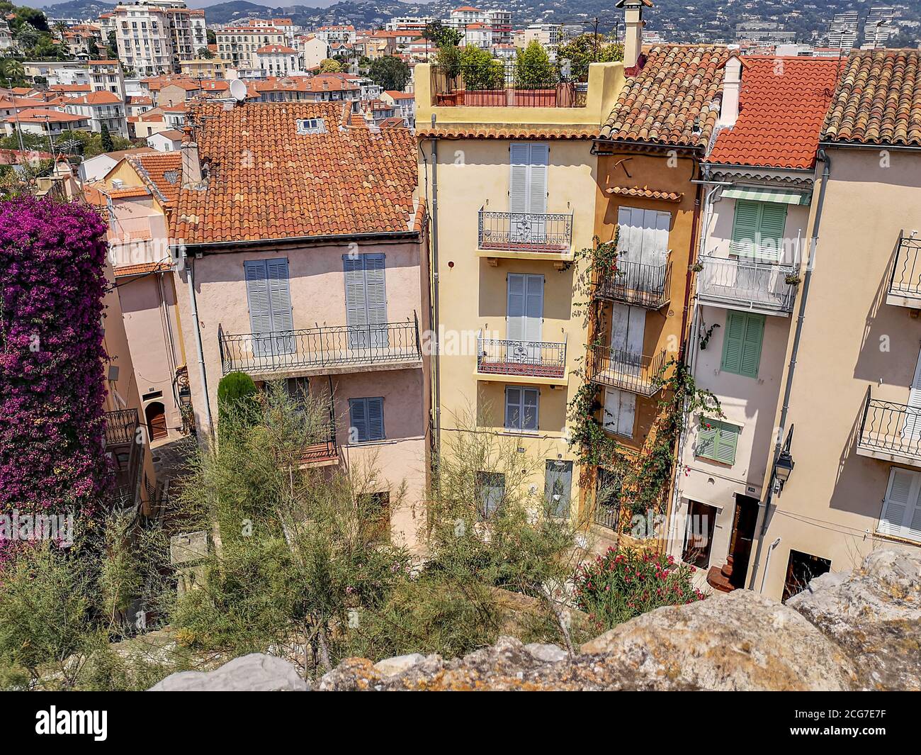 Vista dal muro di pietra sulla collina sulle suggestive vecchie case tradizionali con tetti in tegole rosse, tende da sole in legno, balconi aperti, vasi di fiori. Foto Stock