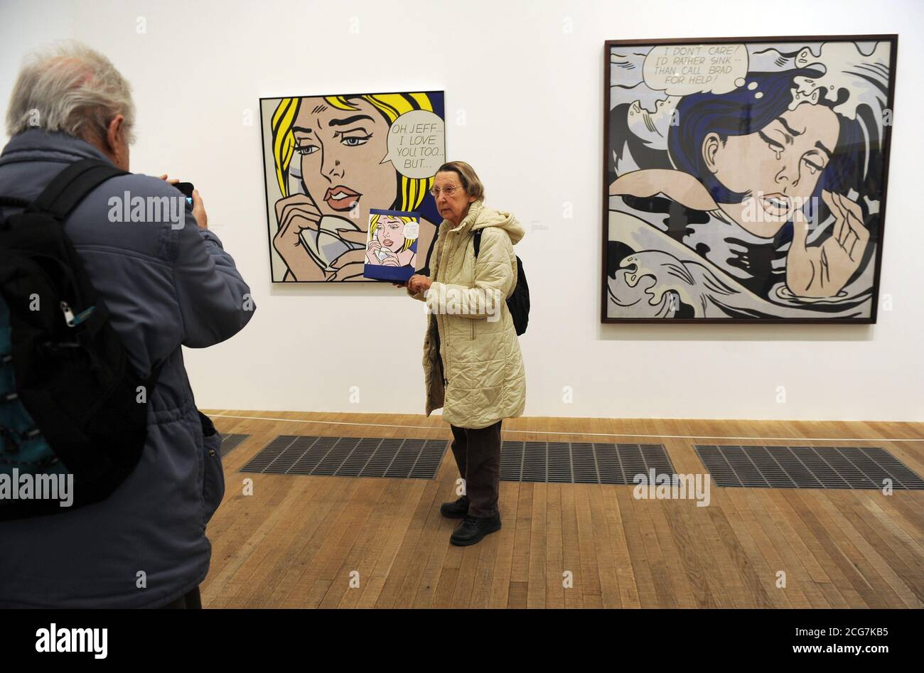 Una donna si pone per una fotografia accanto ai dipinti di Roy Lichtenstein Oh,Jeff...anche io ti amo... ma... 1964 (a sinistra) e Drawning Girl, 1963, durante l'anteprima stampa di Lichtenstein: Una retrospettiva a Tate Modern, Londra. Foto Stock