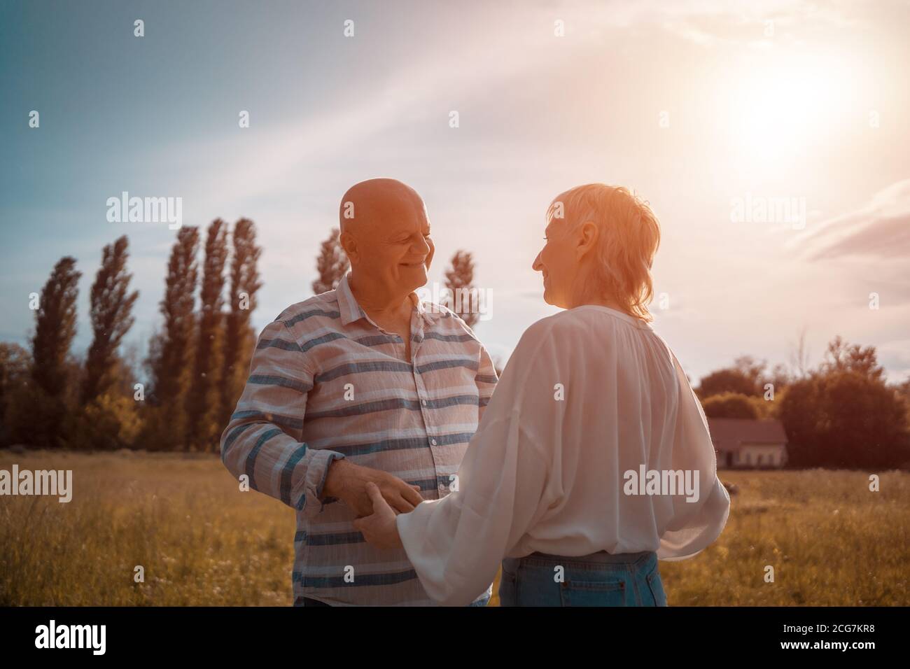 felice coppia senior dating, abbracciando e baciando all'aperto al tramonto Foto Stock