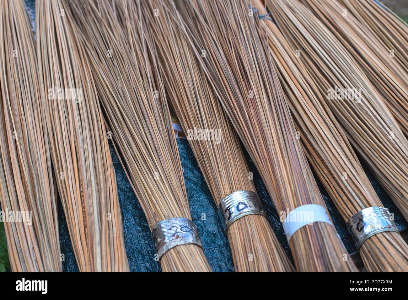 Bastoncini di legno. Scopa rustica in vendita su tavolo di mercato. Materiale naturale per scopa per uso domestico. Rustici bastoni di legno sul tavolo di vendita. ma ecocompatibile Foto Stock