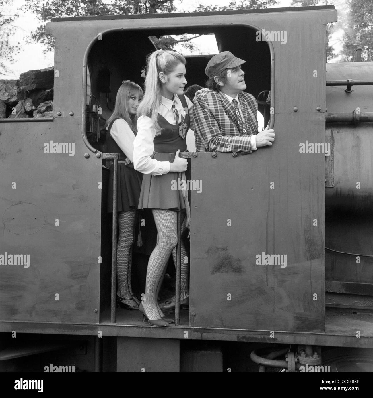 Portland Mason, figlia dell'attrice di James Mason, e George Cole (Flash Harry, la 'libreria' della scuola) sul piatto dei piedi durante le riprese per il 'The Great St. Trinian's Train Robbery' al Longmoor Army Camp, Hampshire. La ferrovia militare del campo è stata utilizzata per le scene del film, in cui Portland debutta come Georgina a St. Trinian's. Foto Stock