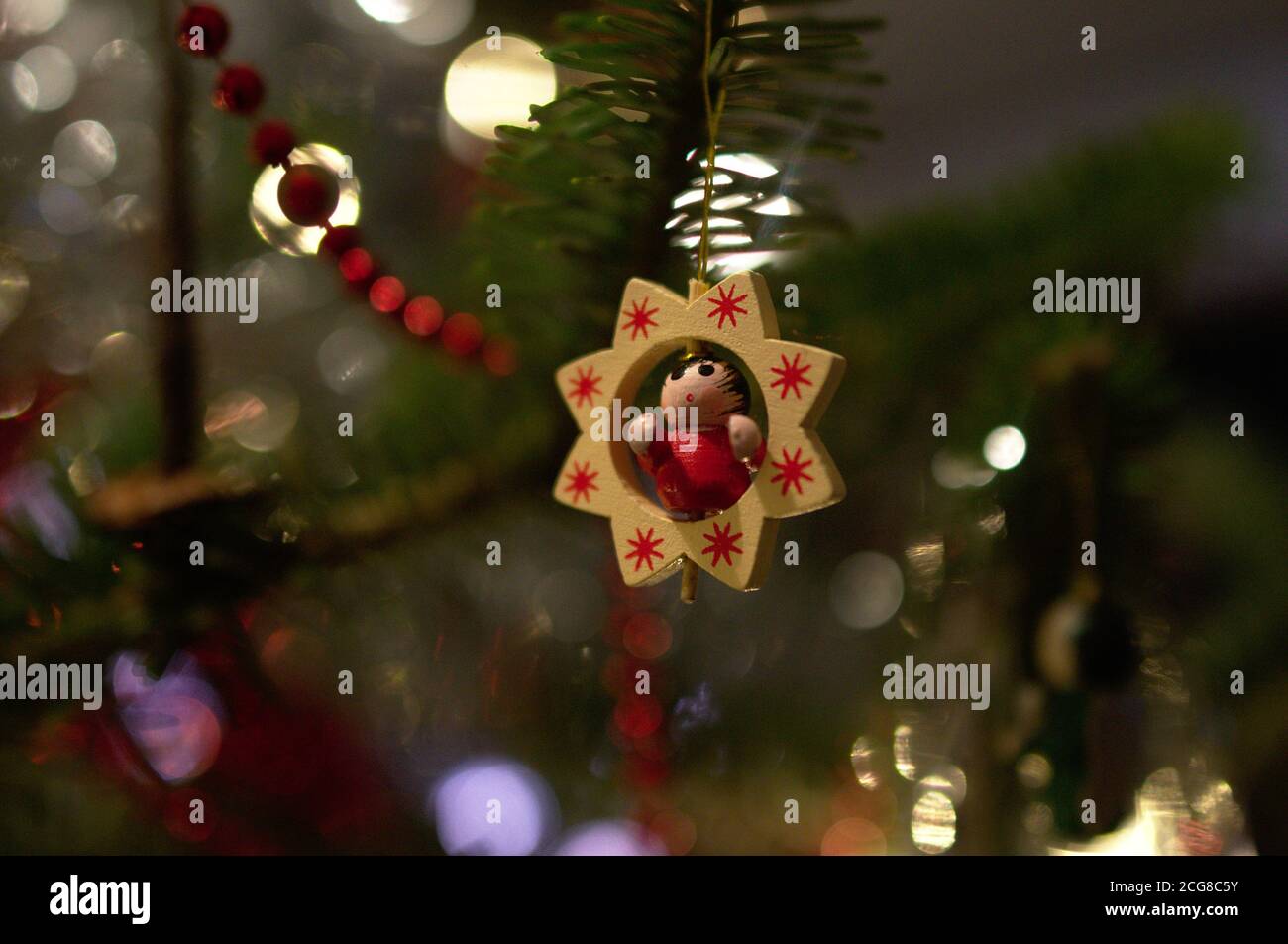 Albero di Natale con poinsettia e piccolo angelo rami di abete rosso collana perla Foto Stock