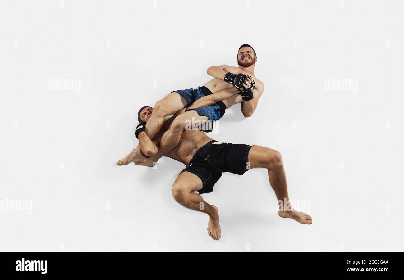 Due combattenti MMA professionisti pugilato isolato su sfondo bianco studio. Vista dall'alto di una coppia di atleti muscolari. Sport, stile di vita sano, competizione, dinamica e movimento, concetto di azione. CopySpace. Foto Stock