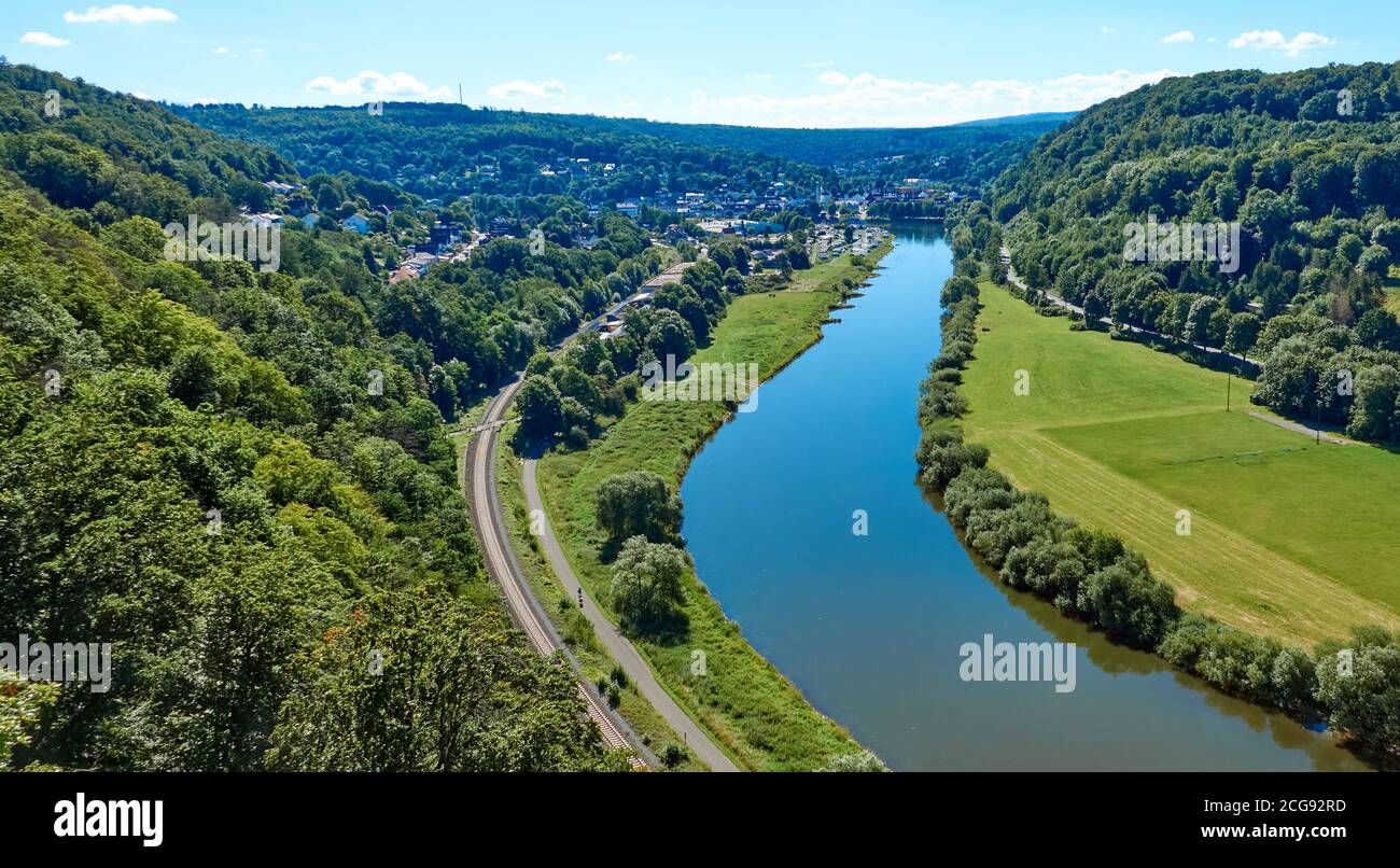 Vista aerea del fiume Weser vicino a Beverungen, Germania, con una pista ciclabile e binari ferroviari sulla riva Foto Stock