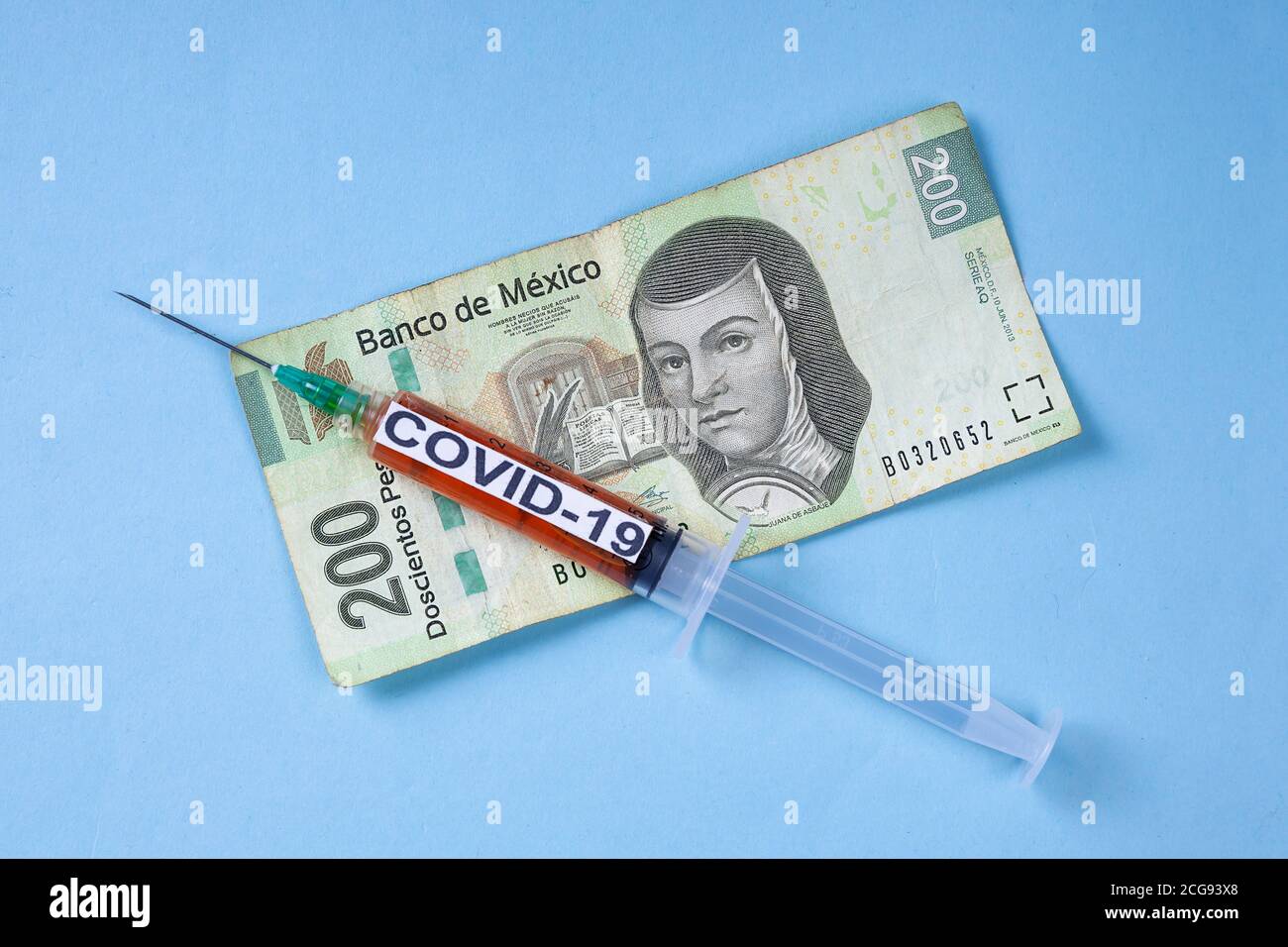 Siringa con vaccino per covid, su banconote messicane Foto Stock