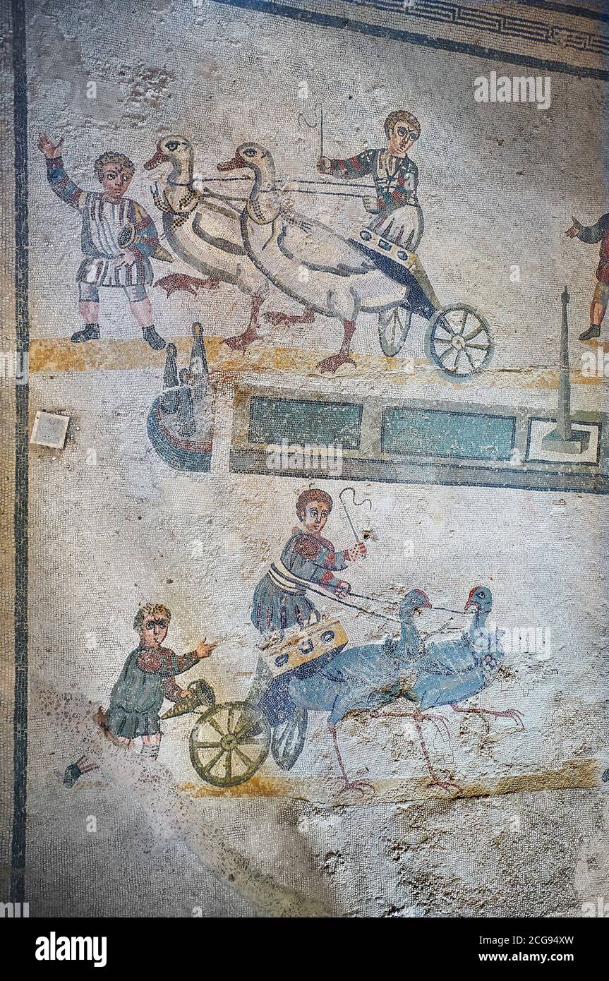 Ampio scatto dei mosaici romani della sala del piccolo Circo raffigurante i ragazzi romani che cavalcano piccoli carri trainati da uccelli in un piccolo circo, i Vesti Foto Stock