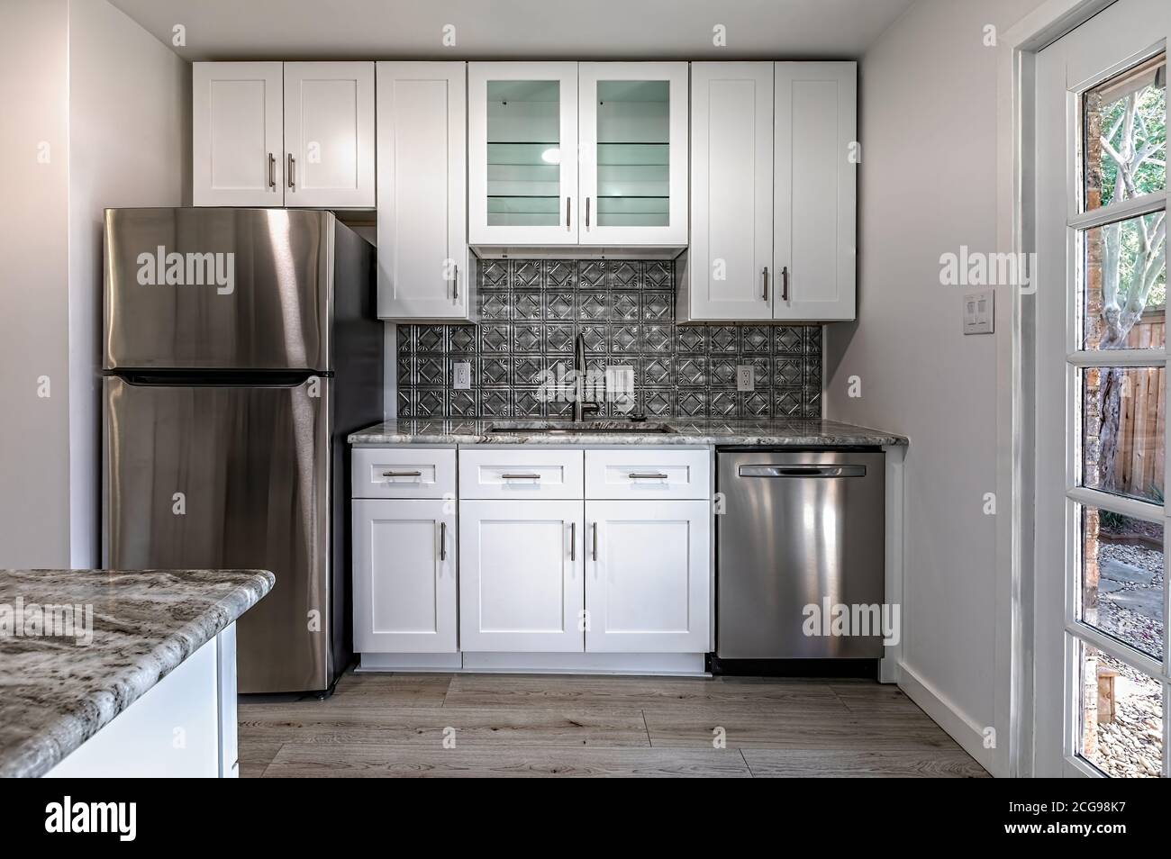 Nuova cucina moderna in un appartamento con elettrodomestici in acciaio inox. Foto reale Foto Stock