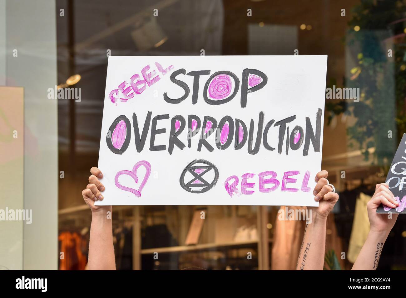 Londra, Regno Unito. 09 settembre 2020. Un cartello che dice "Stop over production" visto durante la riparazione della protesta di ingiustizia.Extinction Rebellion Fashion Action (XRFA) dimostra al negozio H&M di Oxford Street, opponendosi alle numerose ingiustizie umane, animali e ambientali dell'industria della moda sostenendo che, attualmente produce circa il 10% di tutte le emissioni di carbonio dell'umanità. Si prevede che le emissioni aumenteranno di circa il 50% entro il 2030. Credit: SOPA Images Limited/Alamy Live News Foto Stock