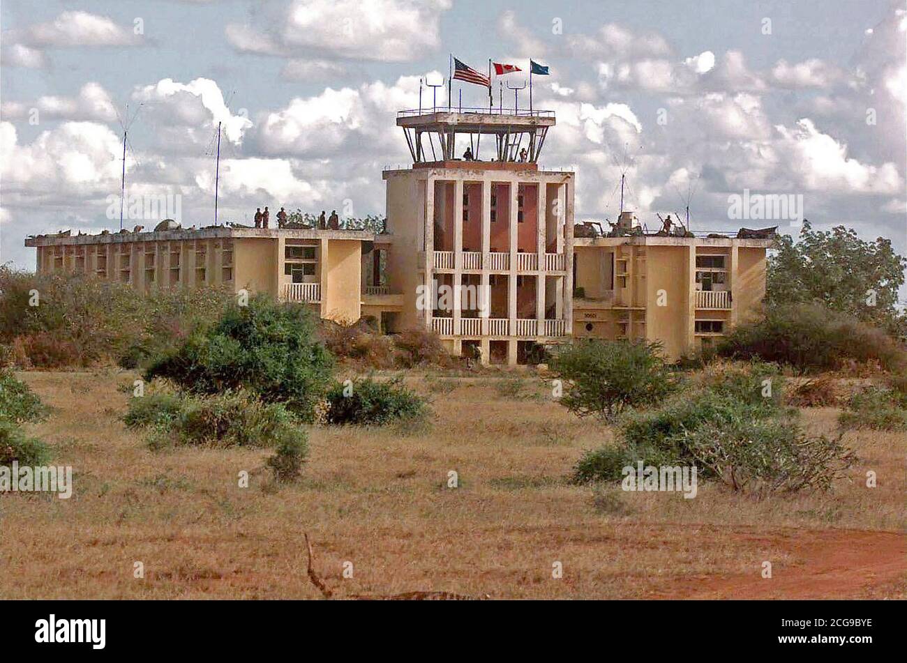 1992 - i soldati combinata di noi e forze canadesi fissare un quartier generale abbandonati e la torre di controllo edificio a Baledogle, Somalia. I membri del Decimo Montagna divisione, Fort tamburo, New York e Air Force Combat Controller sono visibili sul tetto e nella torre di controllo. Le bandiere degli Stati Uniti, in Canada e in seno alle Nazioni Unite di volare al di sopra della torre di controllo. Questa missione è a sostegno dell'operazione Restore Hope. Foto Stock