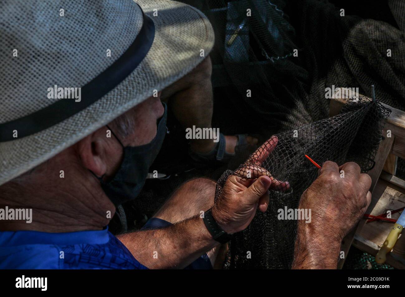 9 settembre 2020: 9 settembre 2020 (Caleta de Velez, Velez Malaga, Malaga) gruppo di pescatori riparano le loro reti nel porto di Caleta de Velez con l'arte di mending. Questo danno alle reti dei pescatori è causato dal delfino in attesa che le barche riempano le loro reti di pesce, ed è in quel momento che si avvicina a mangiare la merce già pescata. Credit: Lorenzo Carnero/ZUMA Wire/Alamy Live News Foto Stock