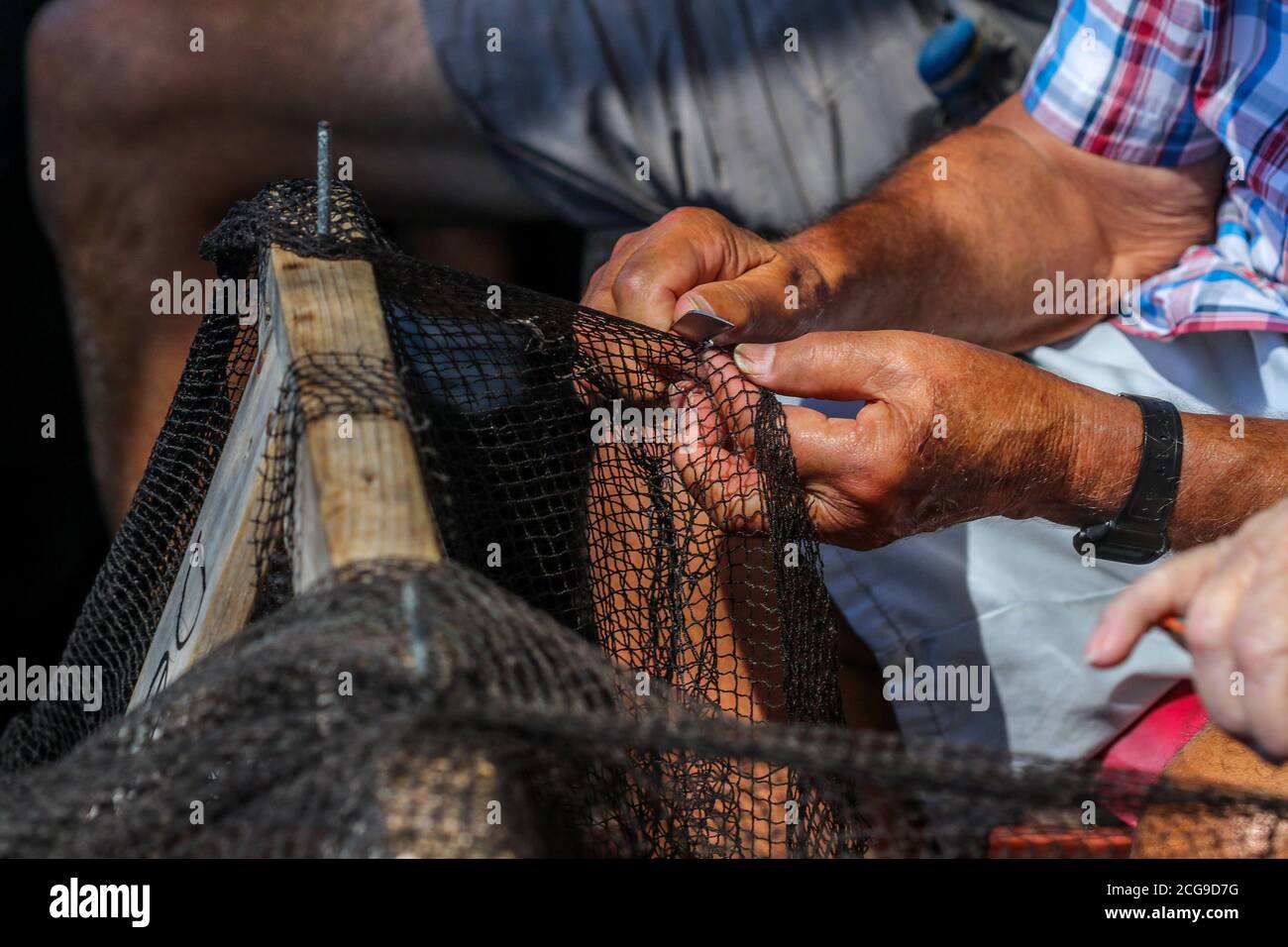 9 settembre 2020: 9 settembre 2020 (Caleta de Velez, Velez Malaga, Malaga) gruppo di pescatori riparano le loro reti nel porto di Caleta de Velez con l'arte di mending. Questo danno alle reti dei pescatori è causato dal delfino in attesa che le barche riempano le loro reti di pesce, ed è in quel momento che si avvicina a mangiare la merce già pescata. Credit: Lorenzo Carnero/ZUMA Wire/Alamy Live News Foto Stock