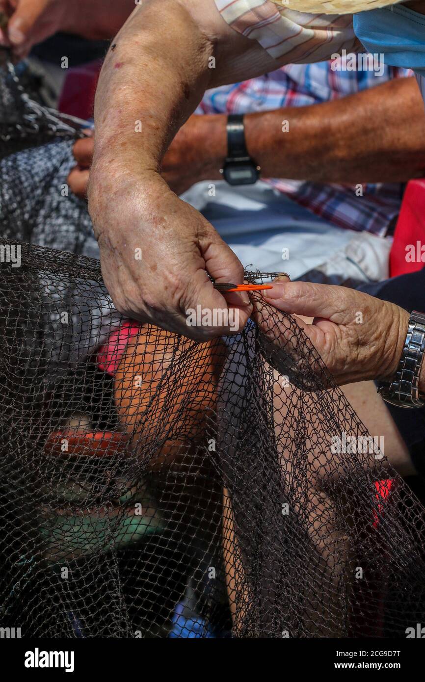 9 settembre 2020: 9 settembre 2020 (Caleta de Velez, Velez Malaga, Malaga) gruppo di pescatori riparano le loro reti nel porto di Caleta de Velez con l'arte di mending. Questo danno alle reti dei pescatori è causato dal delfino in attesa che le barche riempano le loro reti di pesce, ed è in quel momento che si avvicina a mangiare la merce già pescata. Credit: Lorenzo Carnero/ZUMA Wire/Alamy Live News Foto Stock