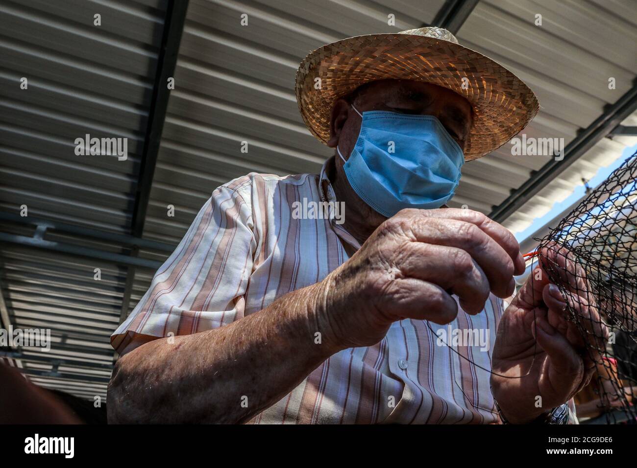 9 settembre 2020: 9 settembre 2020 (Caleta de Velez, Velez Malaga, Malaga) gruppo di pescatori riparano le loro reti nel porto di Caleta de Velez con l'arte di mending. Questo danno alle reti dei pescatori è causato dal delfino in attesa che le barche riempano le loro reti di pesce, ed è in quel momento che si avvicina a mangiare la merce già pescata. Credit: Lorenzo Carnero/ZUMA Wire/Alamy Live News Foto Stock