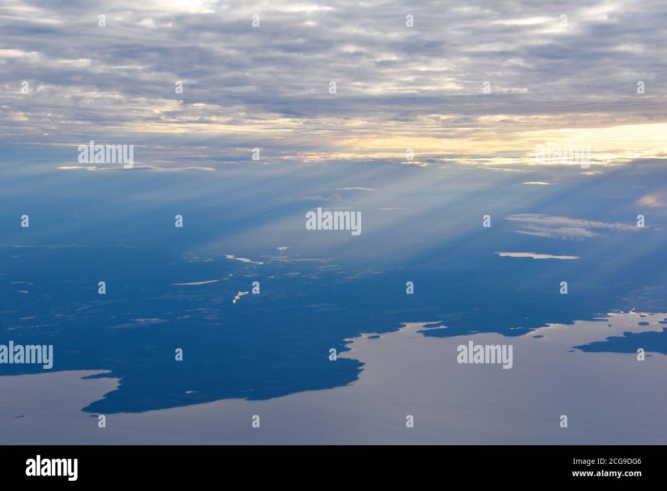 Prospettiva paesaggistica dall'altezza del volo con luce soffusa che penetra nei cieli. Foto Stock