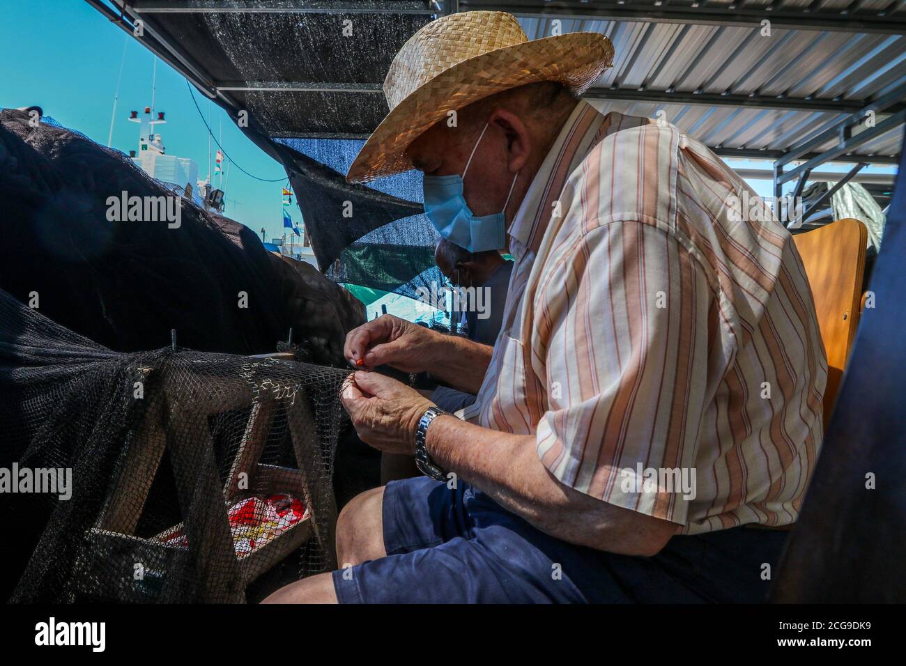 9 settembre 2020: 9 settembre 2020 (Caleta de Velez, Velez Malaga, Malaga) gruppo di pescatori riparano le loro reti nel porto di Caleta de Velez con l'arte di mending. Questo danno alle reti dei pescatori è causato dal delfino in attesa che le barche riempano le loro reti di pesce, ed è in quel momento che si avvicina a mangiare la merce già pescata. Credit: Lorenzo Carnero/ZUMA Wire/Alamy Live News Foto Stock