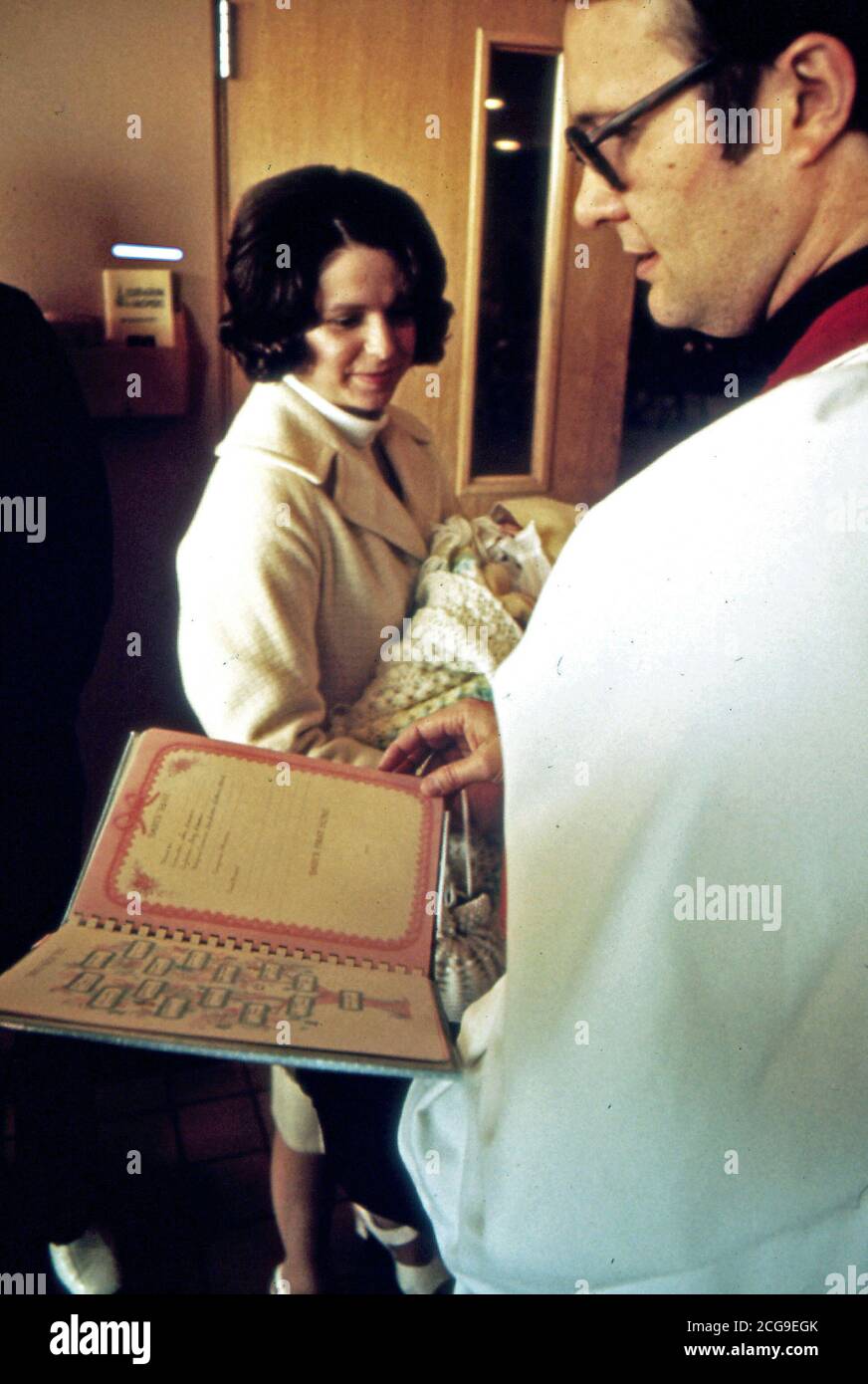 Ottobre 1974 - Una madre è mostrato avente il suo bambino battezzato dopo la chiesa presso il nostro Salvatore. Foto Stock