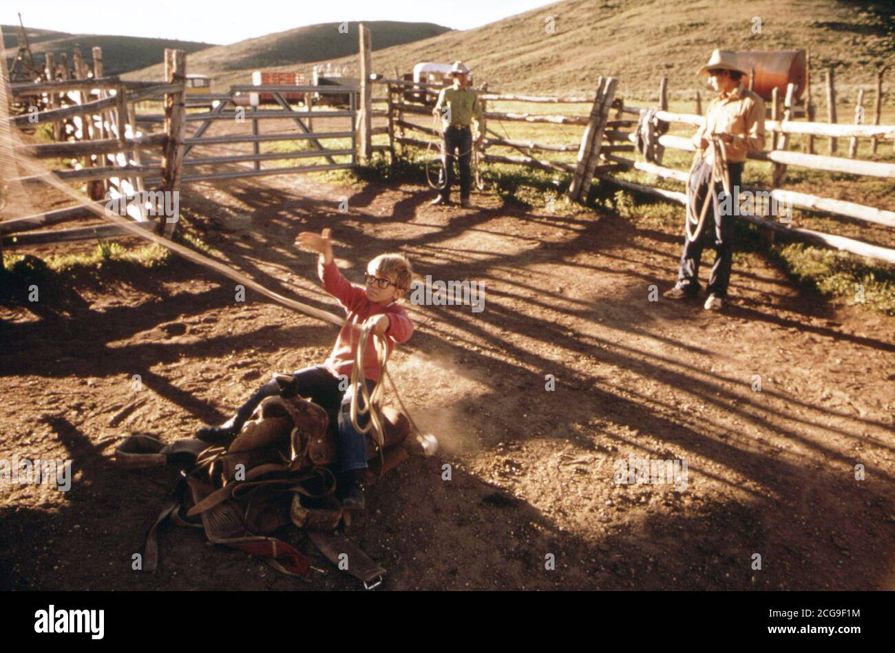 Ragazzo giovane trascorre un momento al minimo la pratica di roping, 07/1973 sul ranch in Garfield County, Colorado 1973 Foto Stock