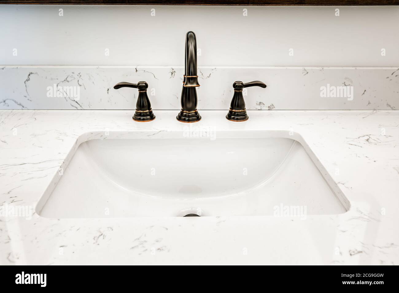 Lavatevi in un bagno domestico con un rubinetto dall'aspetto antico e un bancone in marmo Foto Stock