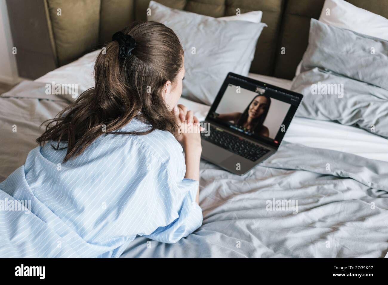 Foto di una bella ragazza messa a fuoco che effettua una videochiamata su  un computer portatile mentre sdraiato sul letto nel soggiorno Foto stock -  Alamy