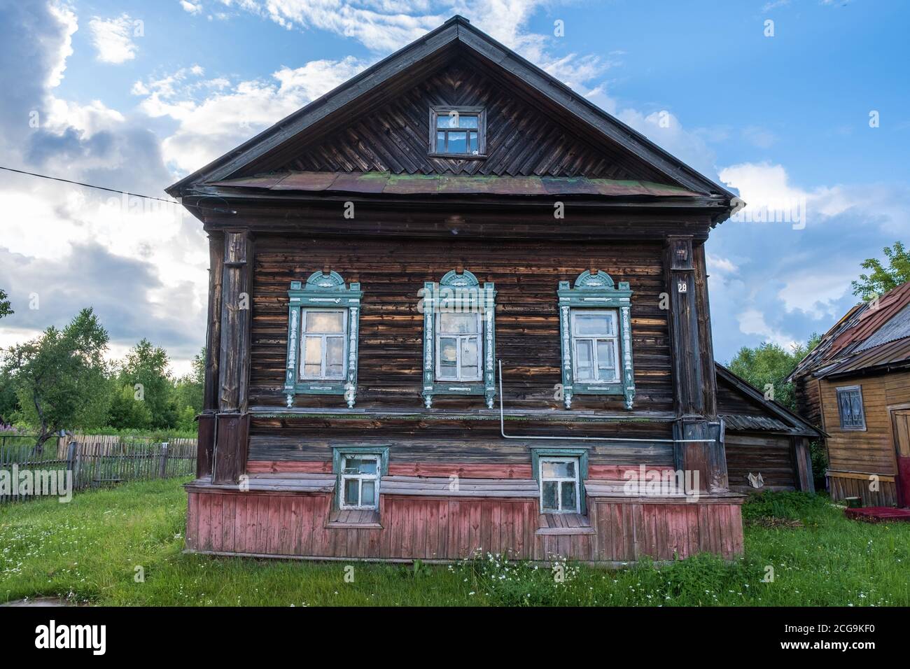 Vecchia casa di villaggio a due piani in legno in una serata estiva, Krasnye Gory villaggio, Ivanovo regione, Russia. Foto Stock