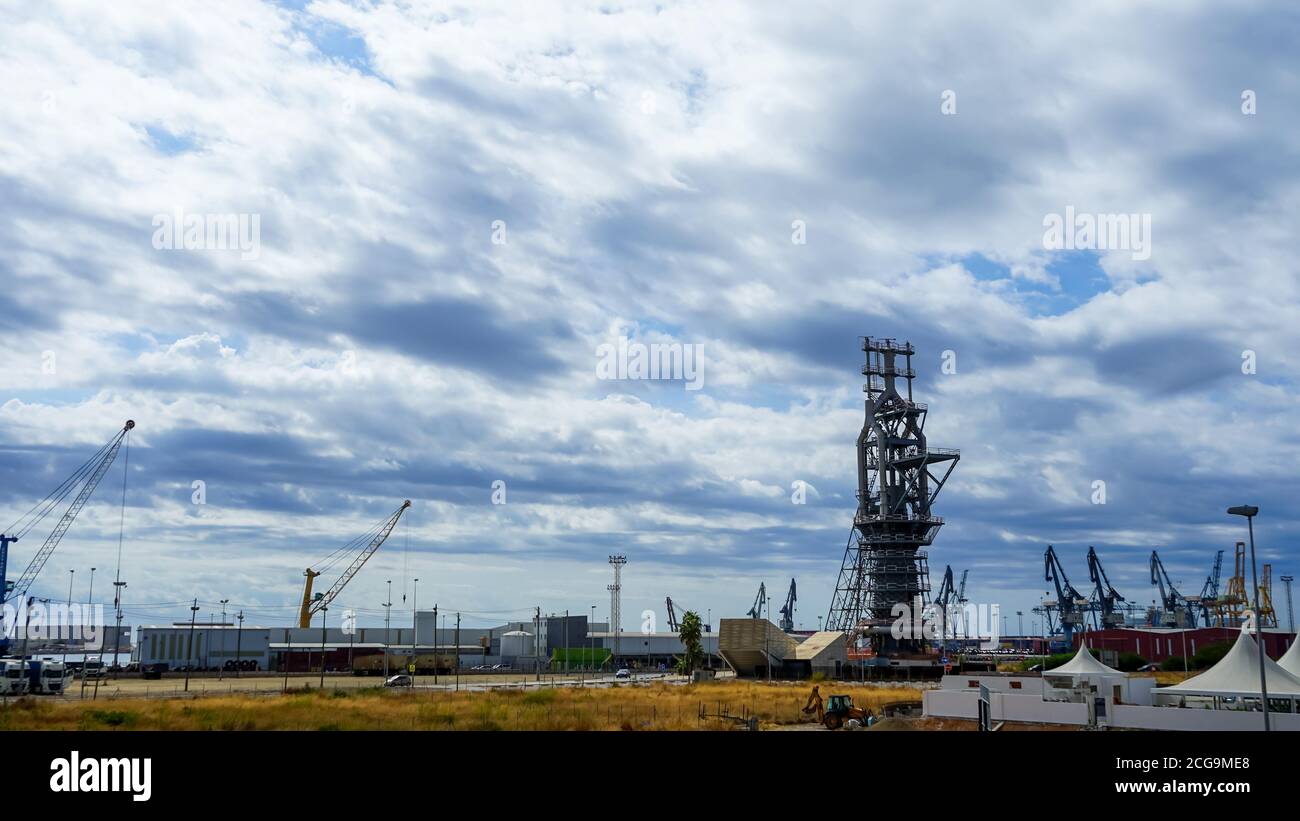 Vista dell'altoforno e delle gru del porto commerciale di Puerto de Sagunto in una giornata nuvolosa. Concetto di tecnologia Foto Stock