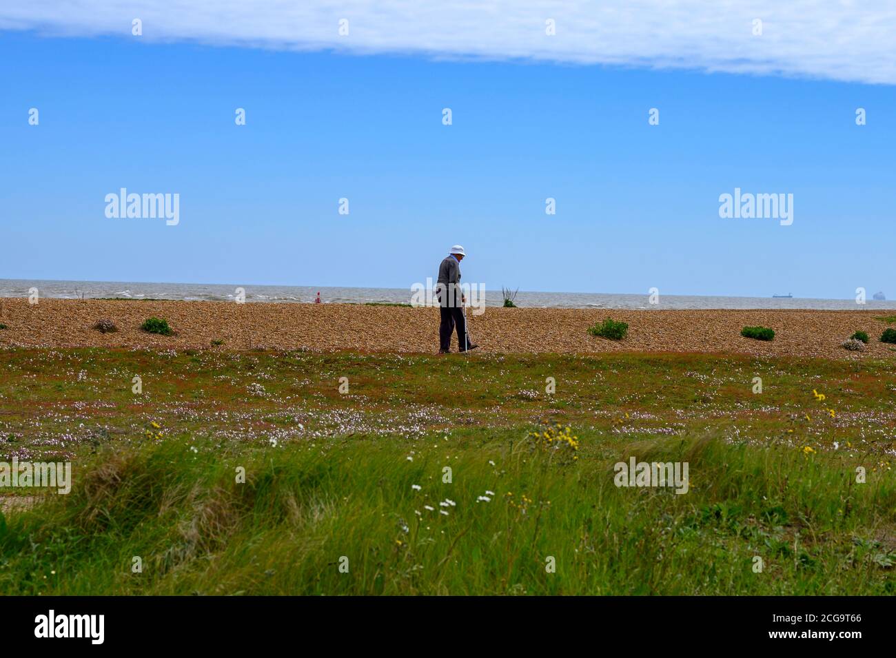 Uomo anziano che cammina sulla spiaggia Foto Stock