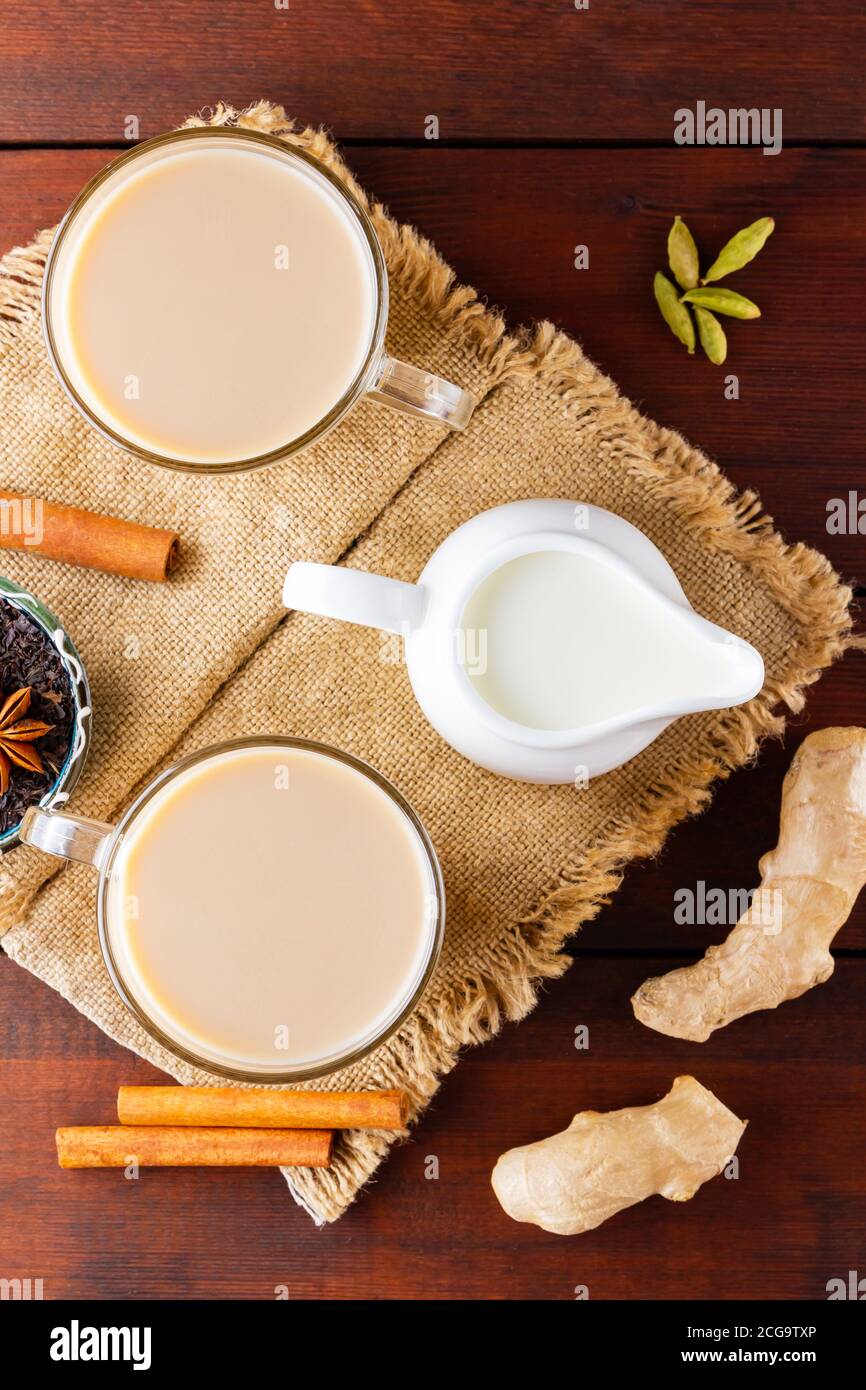 Tè Masala chai sul burlap. Bevanda indiana tradizionale - tè masala con spezie su sfondo di legno. Vista dall'alto Foto Stock