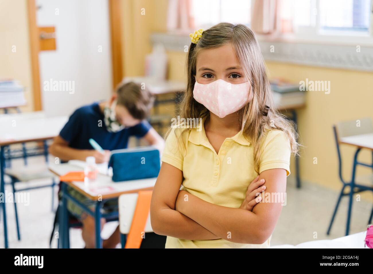 I bambini nella loro classe scolastica indossano maschere durante il covid pandemia Foto Stock