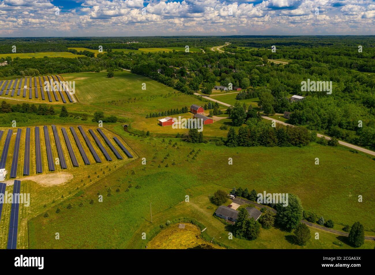 Soia contro silicio, Fattoria con un fienile rosso tradizionale e pianta solare, Lapeer, Michigan, Stati Uniti Foto Stock