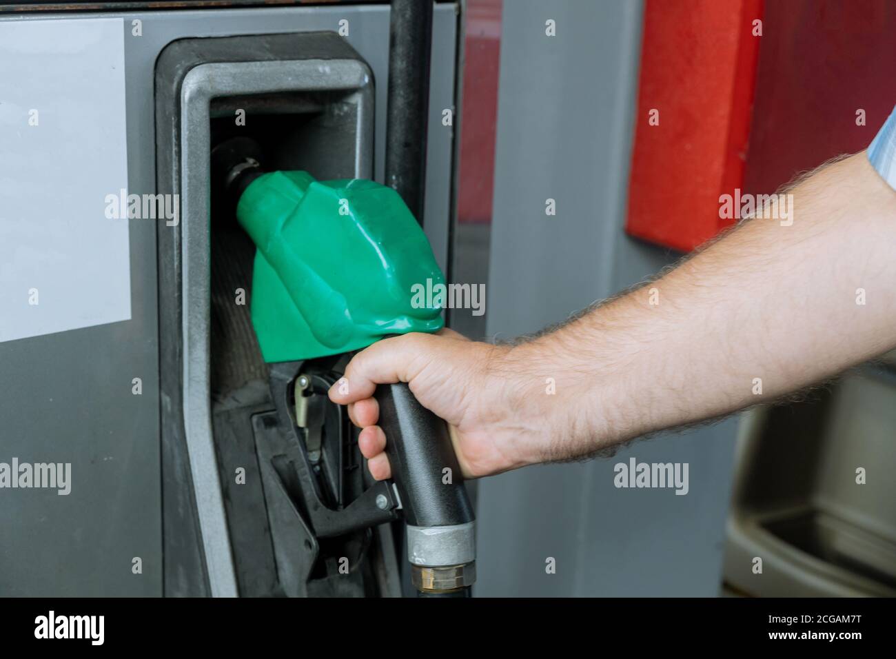 Primo piano del tubo flessibile della benzina che tiene la mano alla stazione di servizio Foto Stock