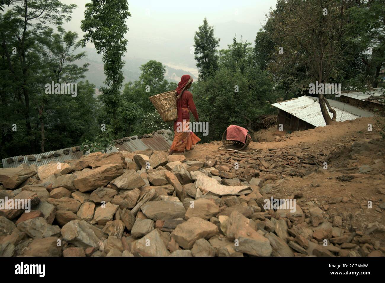 Una donna che cammina attraverso Chandeni (Chandani) Mandan villaggio che pesantemente colpito dai terremoti e frane 2015 a Kavrepalanchok, Nepal. Foto Stock