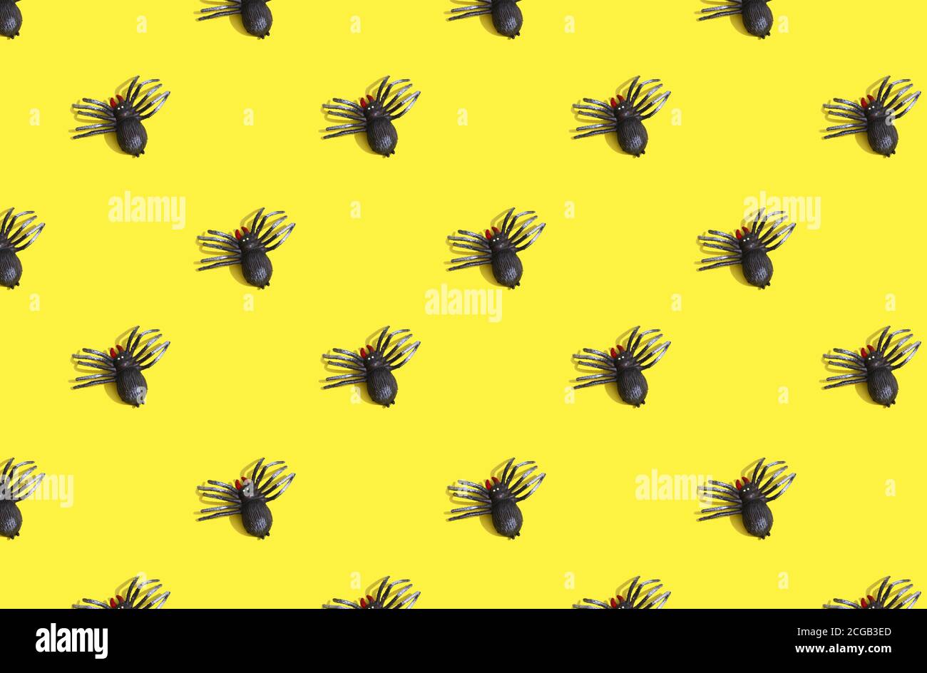 motivo a ragno su sfondo giallo con ombre profonde. Concetto di Halloween. Foto Stock