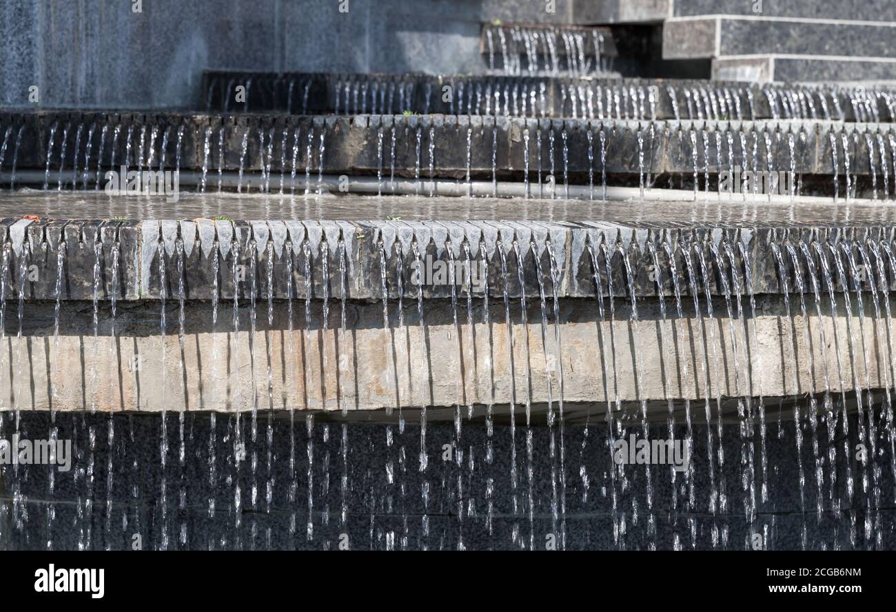 Astratto sfondo architettonico contemporaneo con acqua che si versa su pietra nera scale Foto Stock