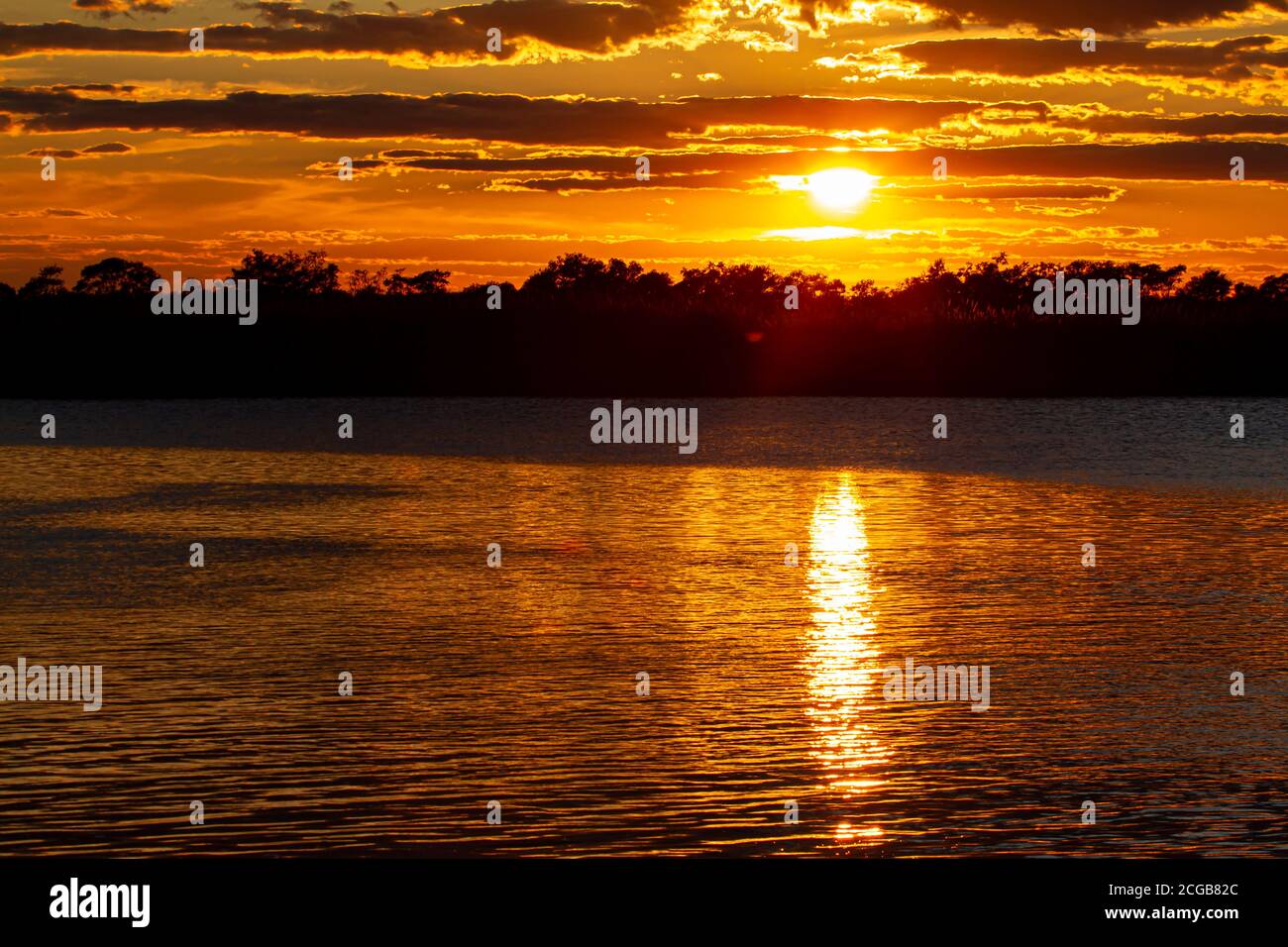 Cielo di tramonto su Eastern Neck Island, rifugio faunistico sulla riva orientale della baia di Chesapeake, Maryland. La luce del sole si riflette dalle nuvole e dall'acqua calma Foto Stock
