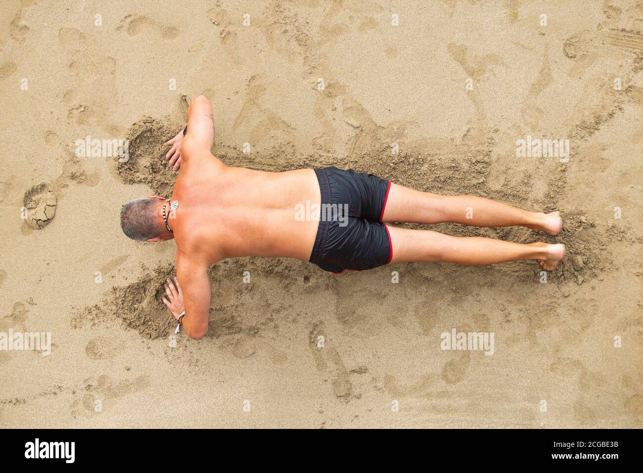 Uomo che fa la stampa su spiaggia. Foto Stock