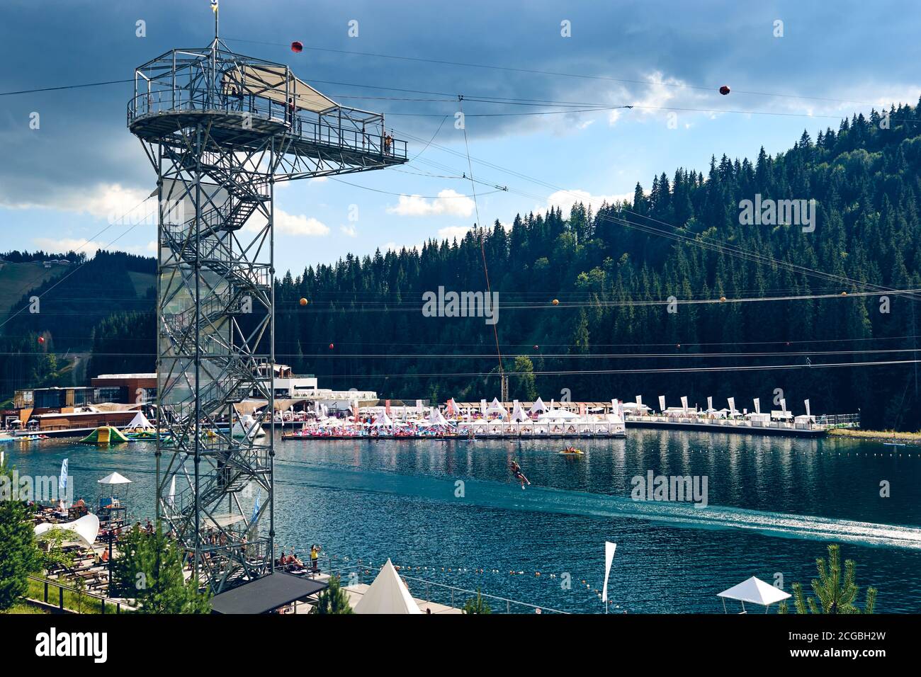 Un sportivo estremo salta su una corda da una grande altezza. Bungy di salto di ropejumping . Felici i giovani che si arrampicano in teleferica estrema strada in foresta Foto Stock