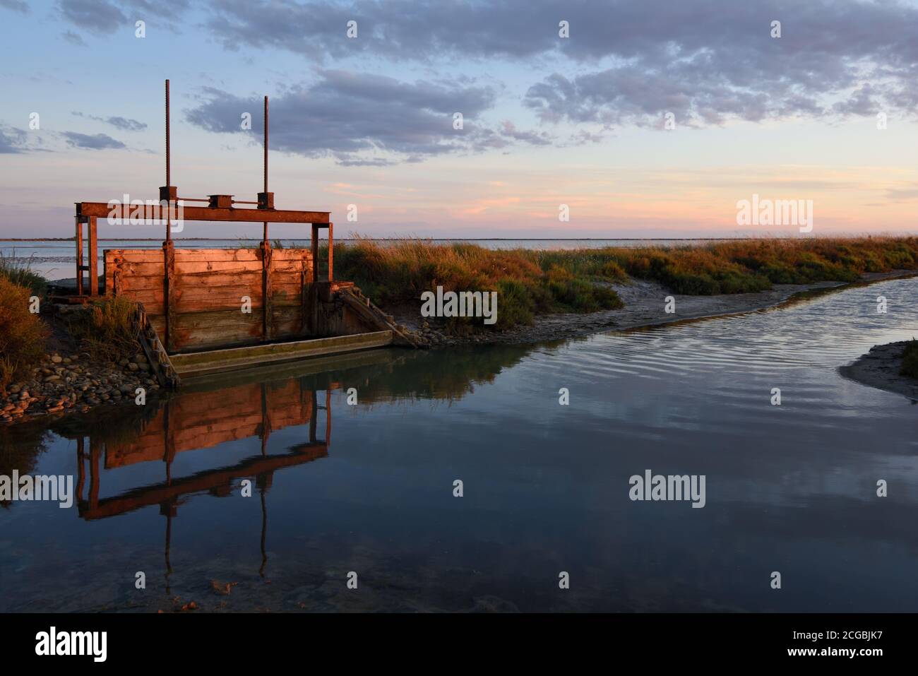 Metallo & legno verticale sollevamento saracinesca usato per il controllo Livelli d'acqua nel lago Etang de la Dame nel Zone umide della Camargue o Riserva Naturale Provenza Foto Stock