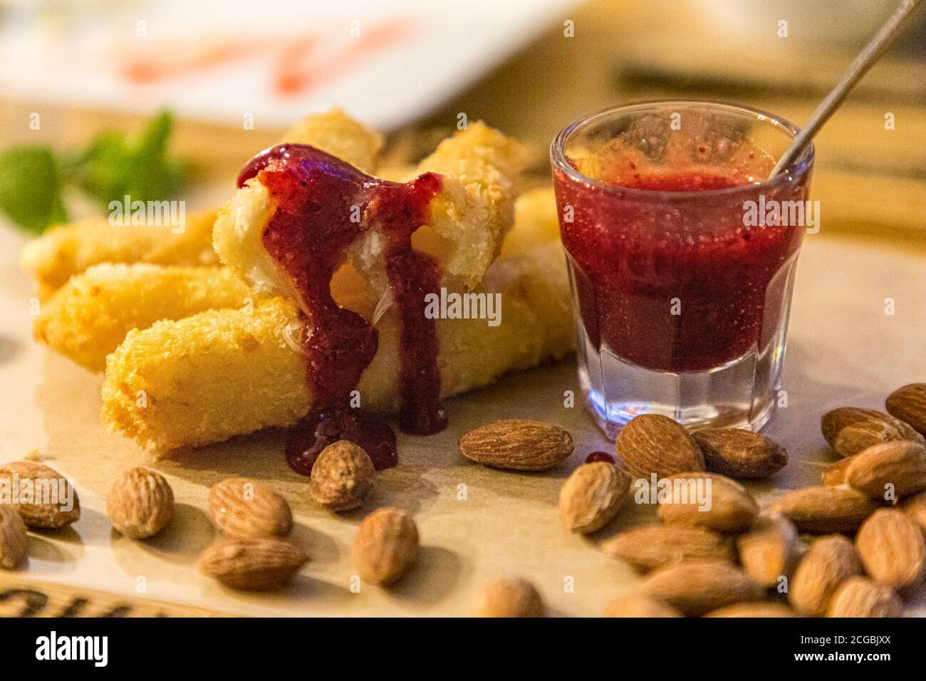 Bastoncini di formaggio conditi con salsa e mandorle sono sul tavolo. Foto Stock