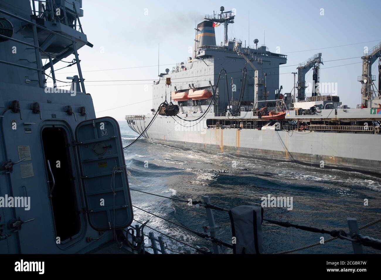 200907-N-FP334-1308 GOLFO PERSICO (SETTEMBRE 7, 2020) l'oliatore per il rifornimento della flotta del comando militare di Sealift USNS Leroy Grumman (T-AO 195) trasferisce i pallet di carico al cacciatorpediniere missile guidato di classe Arleigh Burke USS Ralph Johnson (DDG 114) durante un rifornimento in mare. Ralph Johnson fa parte del gruppo Nimitz Carrier Strike e viene distribuito nella quinta area operativa della flotta statunitense per garantire la stabilità e la sicurezza marittima nella regione centrale. Collegare il Mediterraneo e il Pacifico attraverso l'Oceano Indiano occidentale e tre punti di scelta critici al libero flusso del commercio globale. (STATI UNITI Navy pH Foto Stock